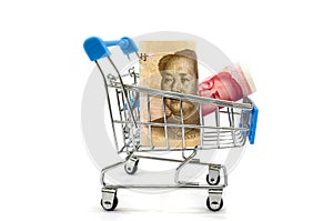 Yuan in a shopping trolley isolated on white background.