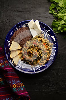 Yucatecan cuisine with our Huevo con Chaya. Scrambled eggs with indigenous chaya, succulent tomatoes, onion, refried beans, and