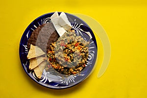 Yucatecan cuisine with our Huevo con Chaya. Scrambled eggs with indigenous chaya, succulent tomatoes, onion, refried beans, and