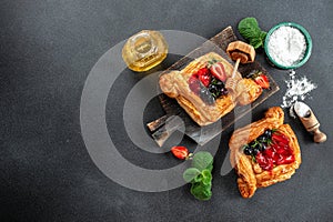 yummy berry puff pastry with berries on a dark background. banner, menu, recipe place for text, top view