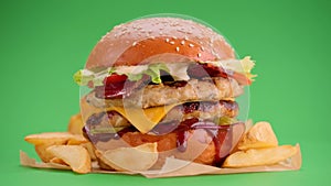 Yummy cheeseburger and fries rotation on a green screen background.