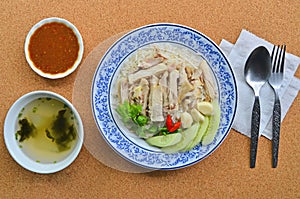 Yummy chicken rice dish with cups of soup and sauce
