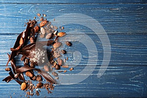 Yummy chocolate candy with cacao beans and curls on wooden table