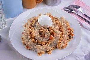 Yummy Nigerian Jollof Rice served with a boiled egg and chopped meat