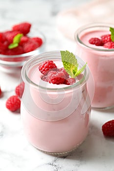 Yummy raspberry smoothie on white marble table, closeup