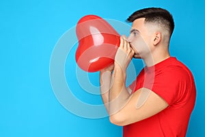 Yuong man blowing balloon