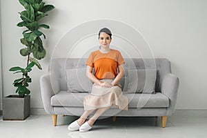 Yuong woman sitting on her white sofa