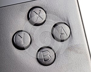 YXAB buttons on a simple retro video game controller, object macro, extreme closeup, nobody. Retro game systems emulation