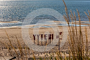 Yyteri Beach and sand dunes on the shore of Baltic Sea in Pori, Finland with Yyteri sign framed by out-of-focus grasses