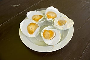 z salted duck egg telur asinserved in white plate isolated on wood background