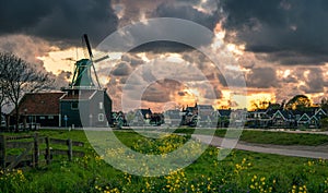 Zaanse Schans windmill landscape in the Netherlands, sunset cloudy sky