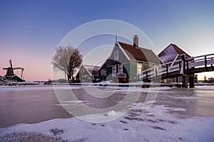 Zaanse Schans windmill village during winter with snowy landscape, snow covered wooden historical windmills Zaanse