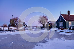 Zaanse Schans windmill village during winter with snowy landscape, snow covered wooden historical windmills Zaanse