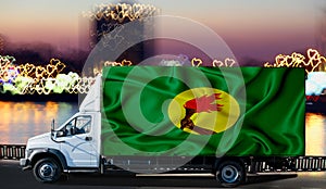 Zaire flag on the side of a white van against the backdrop of a blurred city and river. Logistics concept