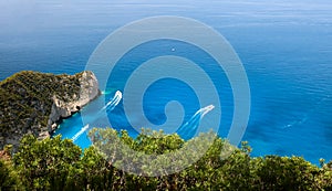 Zakynthos Island, Greece. View on boats, rocky shore and turquoise, crystal clear waters of Ionian Sea