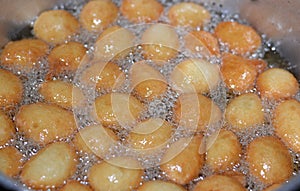 Zalabia a type of fried dough similar to that of a doughnut frying in boiling hot oil in a deep fryer at home