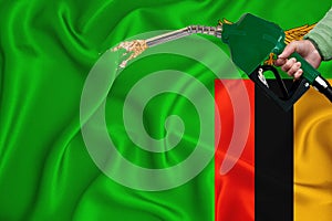 ZAMBIA flag Close-up shot on waving background texture with Fuel pump nozzle in hand. The concept of design solutions. 3d