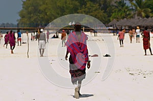 Zanzibar,Masai with typical costume walks on the beach