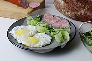 Zastrak eggs scrambled eggs sausage salad cucumbers on the trael view from the side top. Traditional English American breakfast.