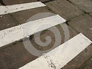 Zebra crossing. Asphalt background texture with some soft shades and spots.Road with black and white crosswalk