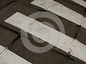 Zebra crossing. Asphalt background texture with some soft shades and spots.Road with black and white crosswalk