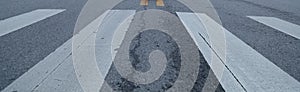 The zebra crossing on the road.Close-ups of white lines, gray roads