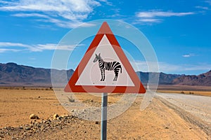 Zebras crossing warning road sign placed in the desert of Namibia