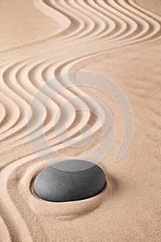 Zen background with stone and pattern of lines in the sand