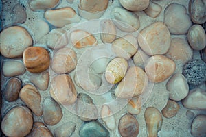 Zen background, stone at the sea, pebbles in shallow water. Peaceful bright nature concept