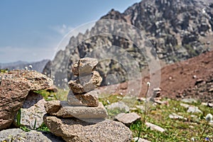 Zen balanced stones stack in high mountains. Pyramidal of stones against the backdrop of a picturesque mountain valley