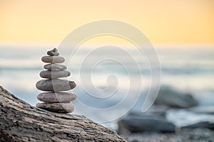 Zen balanced stones stacked on sea coast at sunset