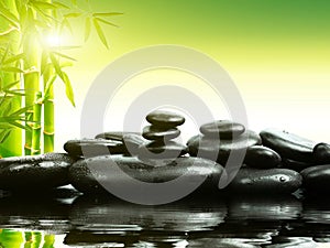 Zen basalt stones with green bamboo on water. Spa and Wellness concept.