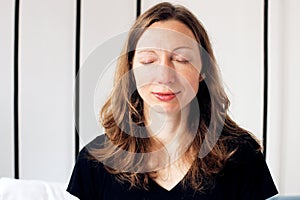 Zen Business Woman doing breathing exercises on bed relaxed in lotus pose