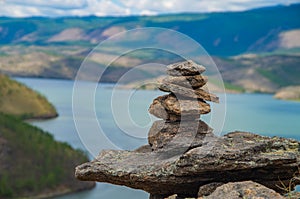 Zen concept. A pyramid made of stone on top of a mountain against the backdrop of Lake Baikal