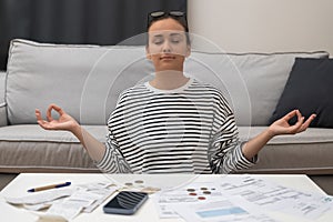 Zen Finance, woman meditates, finding calm after financial stress calculating utility bill and taxes
