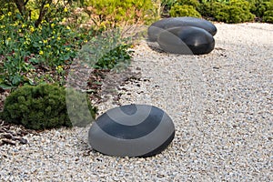 Zen garden dry landscape, or karesansui, japanese rock garden with black stones on white gravel for relaxation and