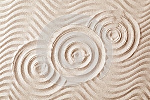 Zen garden pattern on sand as background, top view