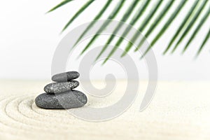 Zen garden. Pyramids of white and gray zen stones on the white sand with abstract wave drawings.