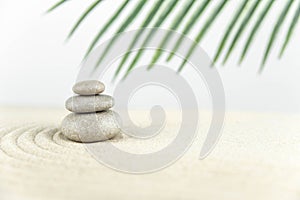 Zen garden. Pyramids of white and gray zen stones on the white sand with abstract wave drawings.