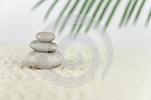 Zen garden. Pyramids of white and gray zen stones on the white sand with abstract wave drawings.