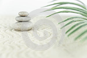 Zen garden. Pyramids of white and gray zen stones on the white sand with abstract wave drawings.