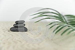 Zen garden. Pyramids of white and gray zen stones on the white sand with abstract wave drawings.