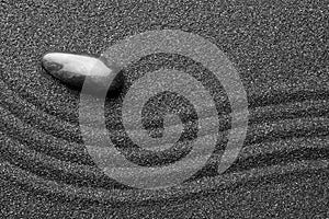 Zen garden stone on black sand with pattern