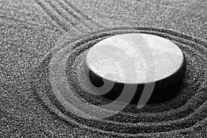 Zen garden stone on black sand with pattern