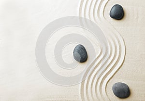 Zen garden stones on sand with pattern, top view.