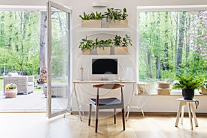 Kancelář počítač v krásný prostorný obývací pokoj rostliny mimo přes velký okna 