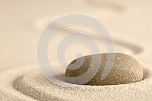 Zen meditation stone with raked line in sand