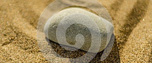 zen meditation stone in sand, concept for purity harmony and spirituality, spa wellness and yoga background