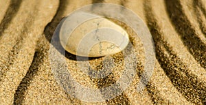 zen meditation stone in sand, concept for purity harmony and spirituality, spa wellness and yoga background