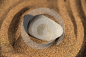 zen meditation stone in sand, concept for purity harmony and spirituality, spa wellness and yoga background